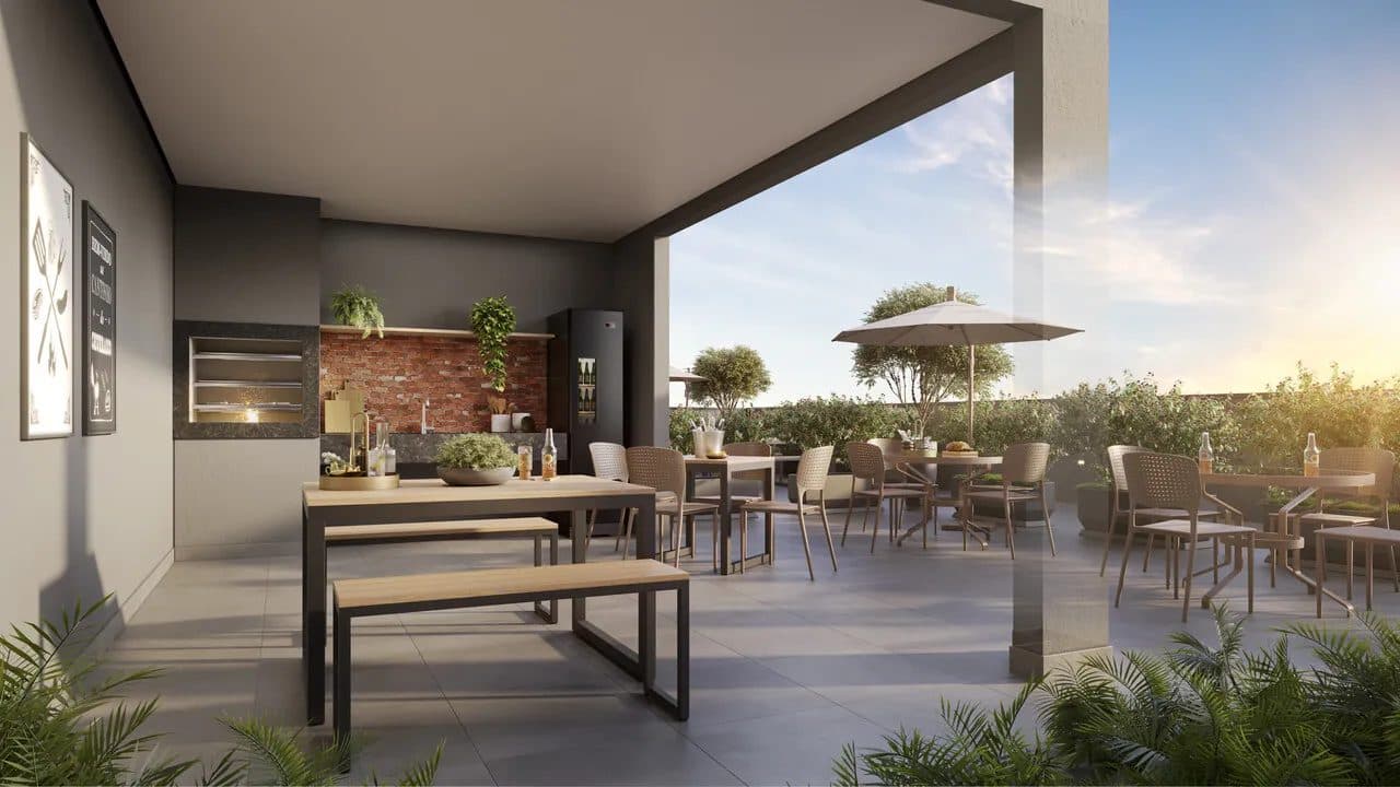 Área gourmet externa com churrasqueira, pia, mesas com bancos e guarda-sol ao ar livre